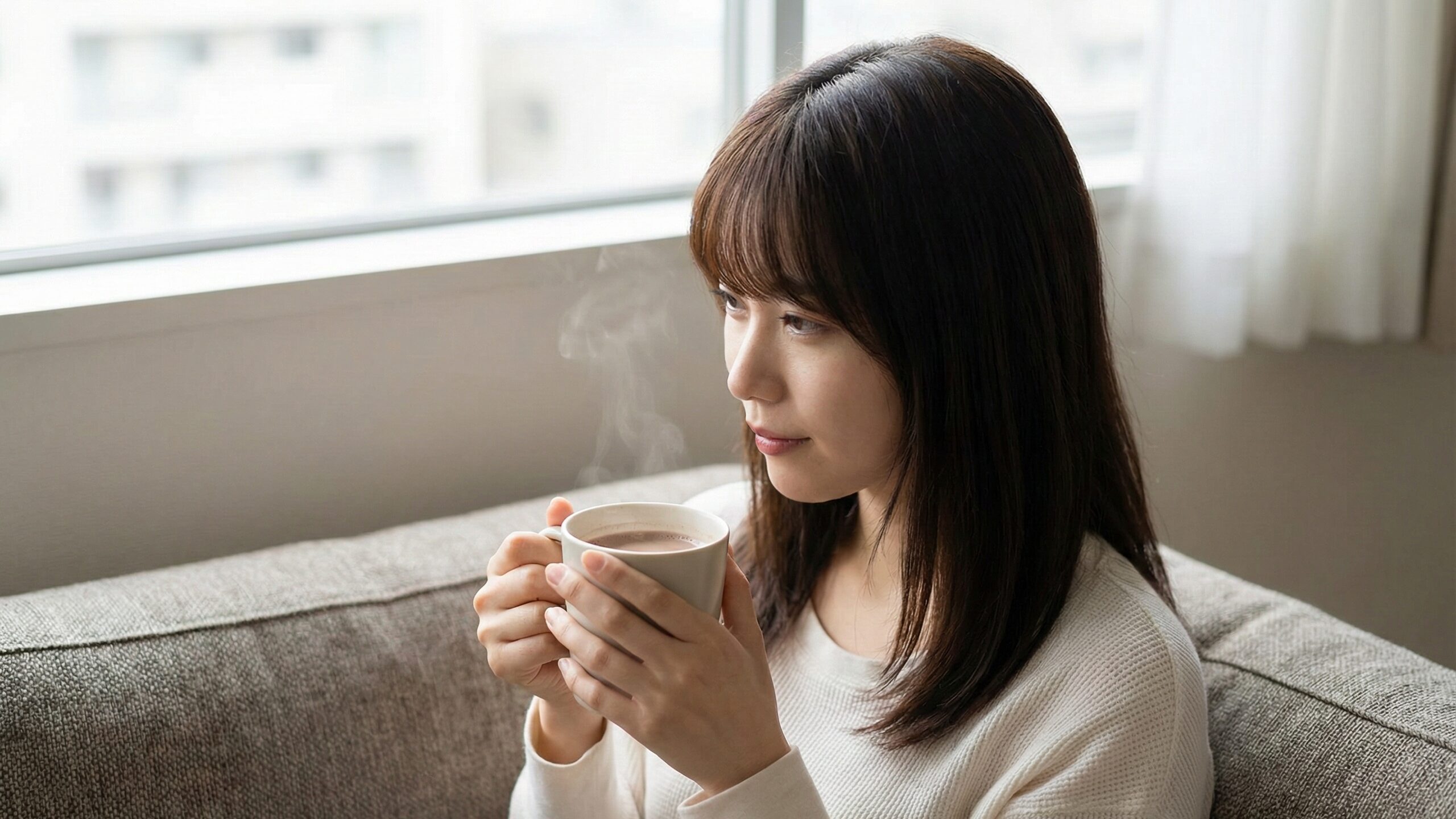 自宅での休憩時間に、無理なく食物繊維を摂り入れられる温かいココアを飲んでリラックスする女性。