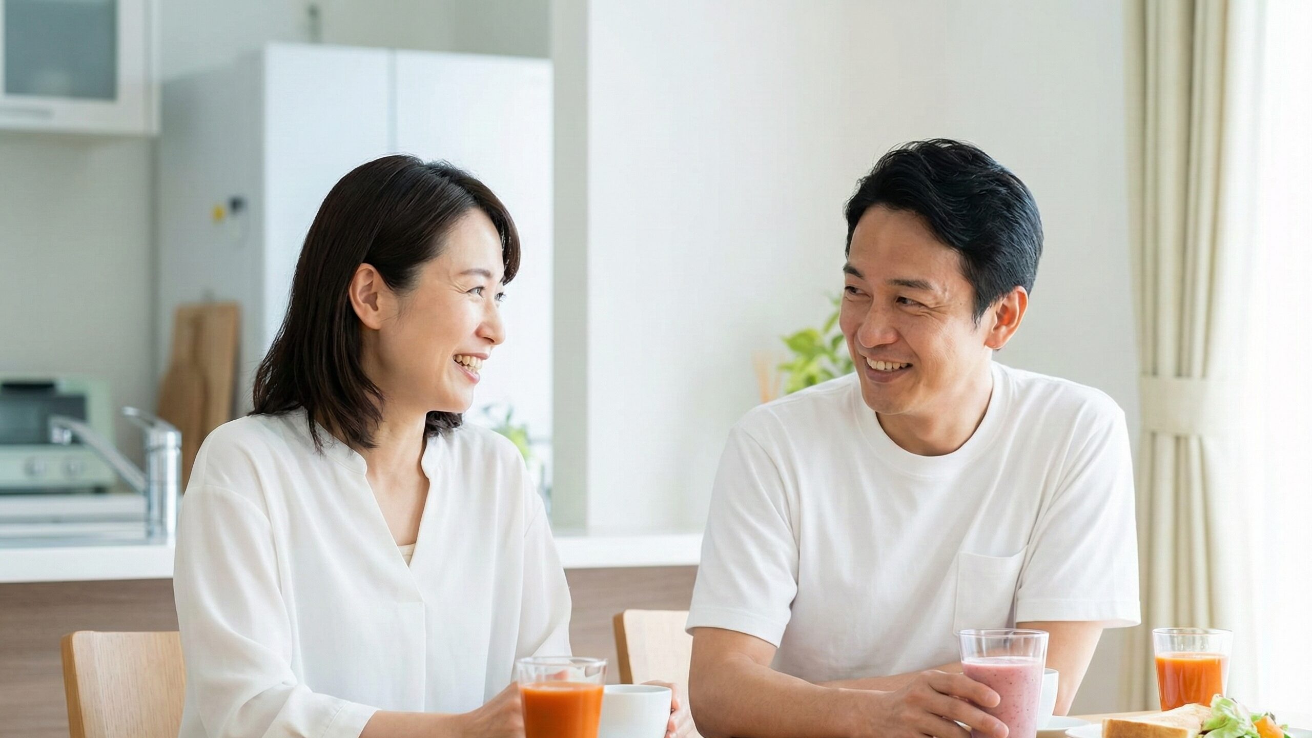 健康維持のために食物繊維が豊富な飲み物を毎日の生活に摂り入れ、談笑しながら楽しむ夫婦。