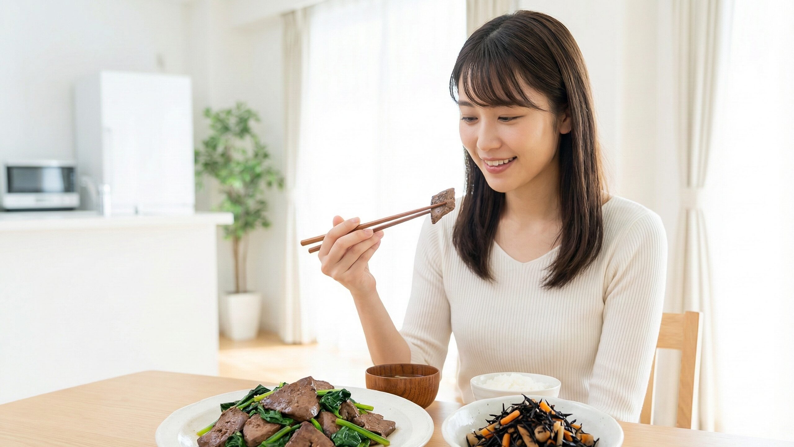 ミネラルが豊富なレバー炒めとひじきの煮物を楽しむ女性