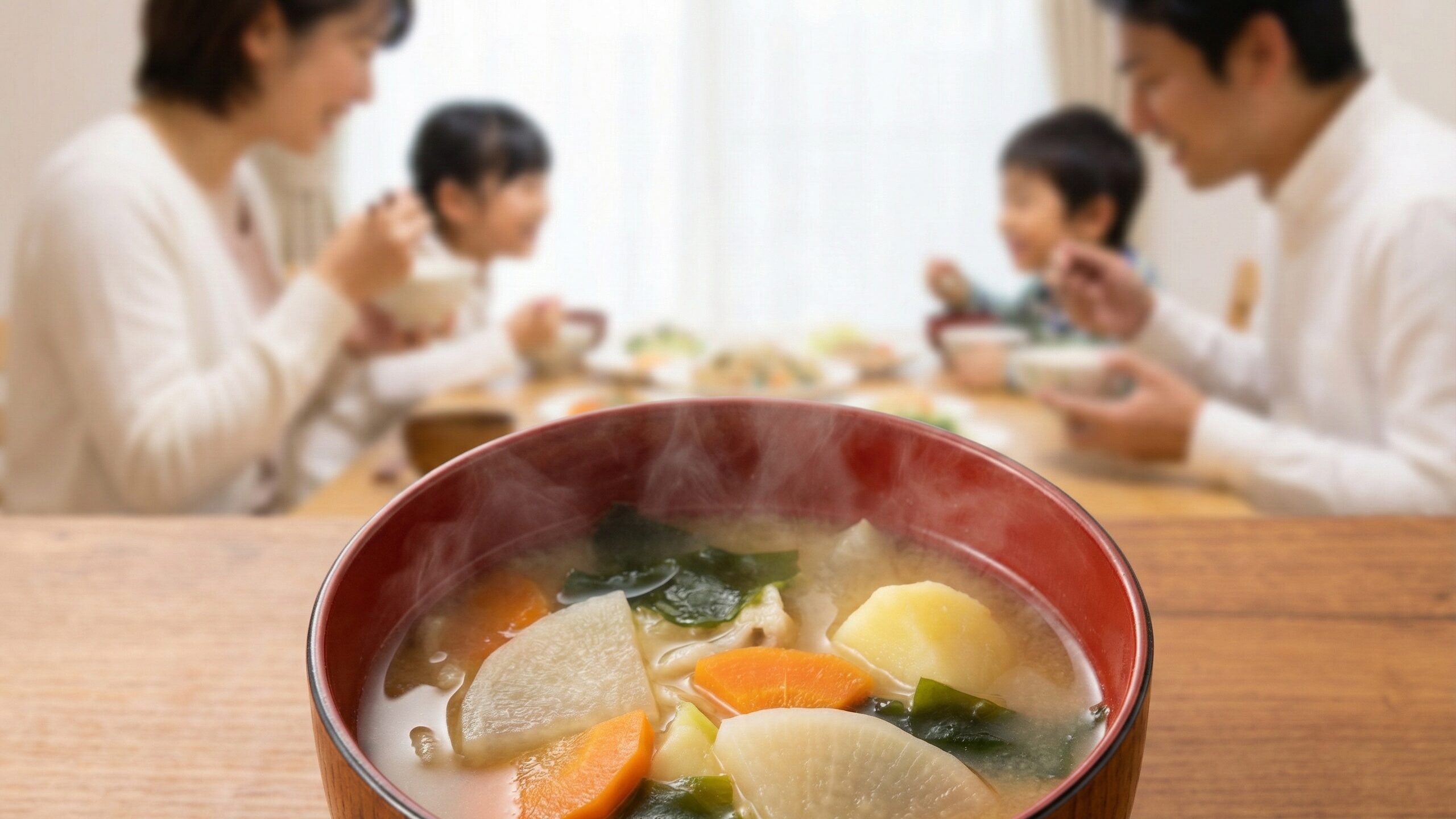 ミネラル豊富な海藻や根菜がたっぷり入った味噌汁を楽しむ家族の団らん風景