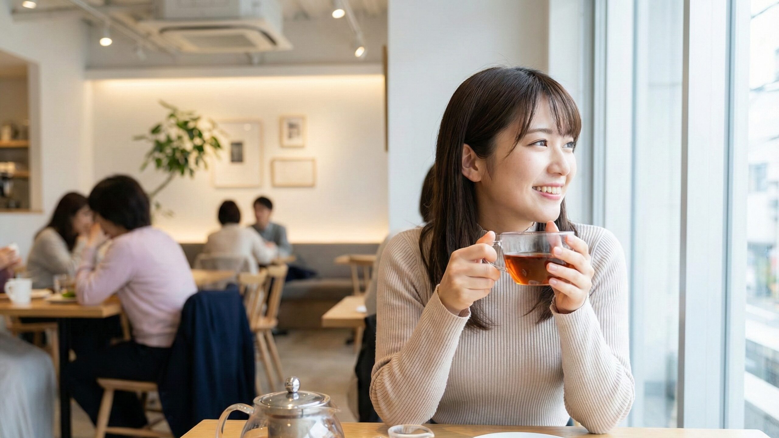 カテキンやテアフラビンなどのポリフェノールを含む紅茶をカフェで楽しむ女性。