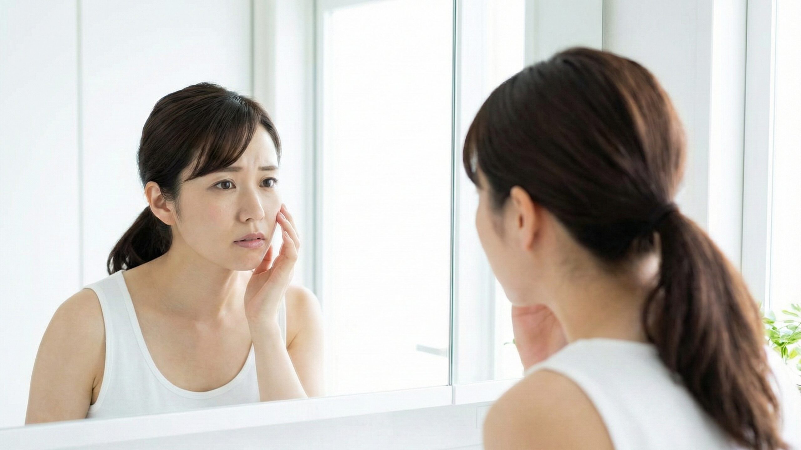 肌荒れや乾燥を鏡でチェックする女性